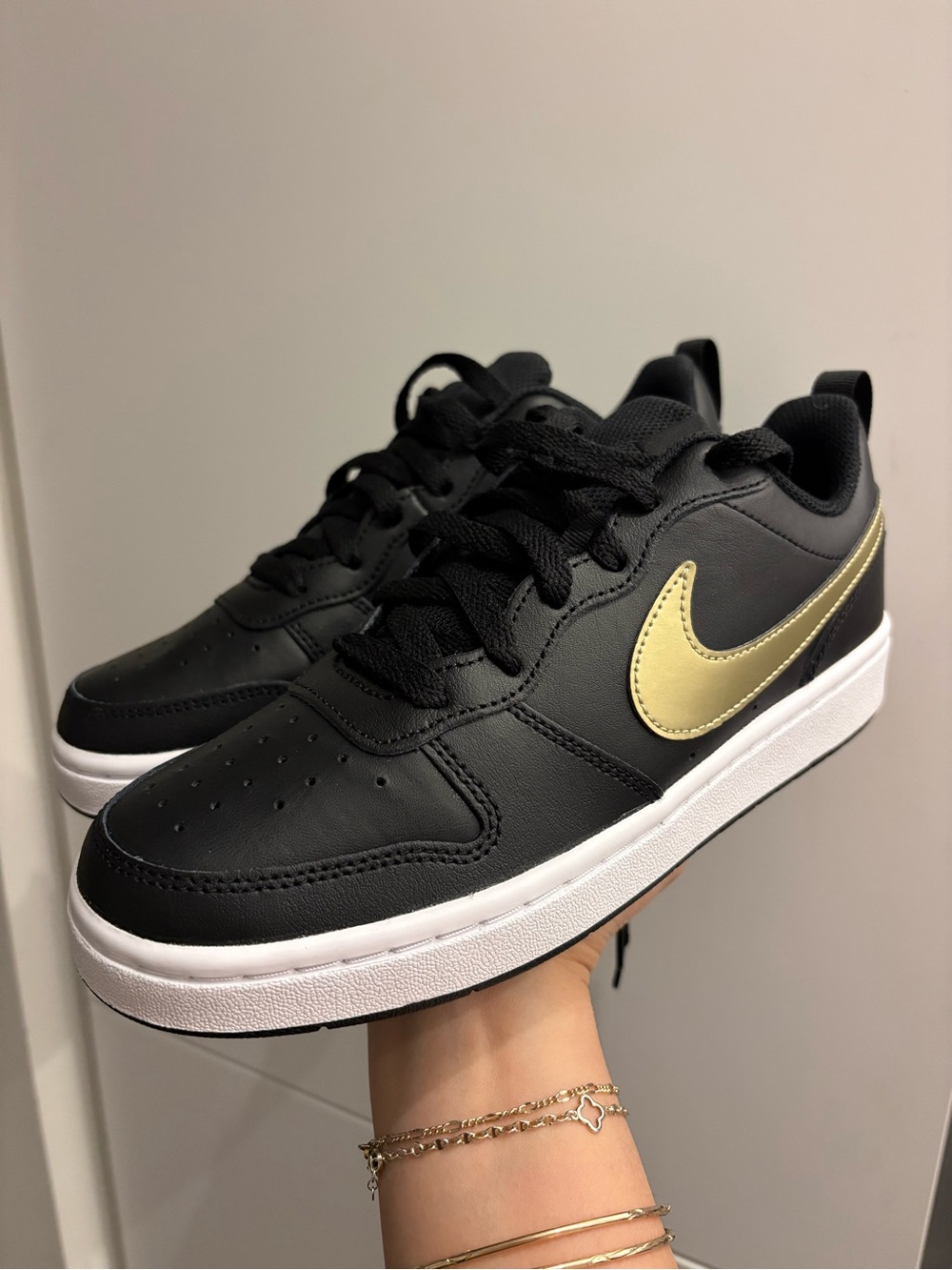 Nike Kids Black Sneakers with Gold Swoosh Accent
